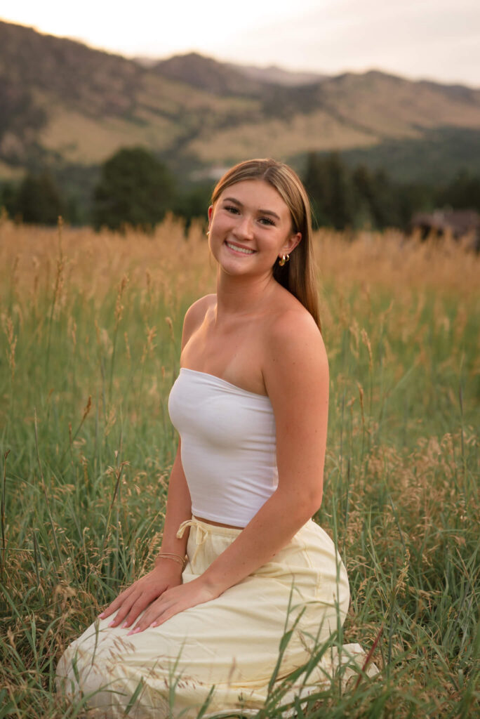 Boulder senior photo at Chautauqua Park with Flatirons mountain backdrop and golden meadow