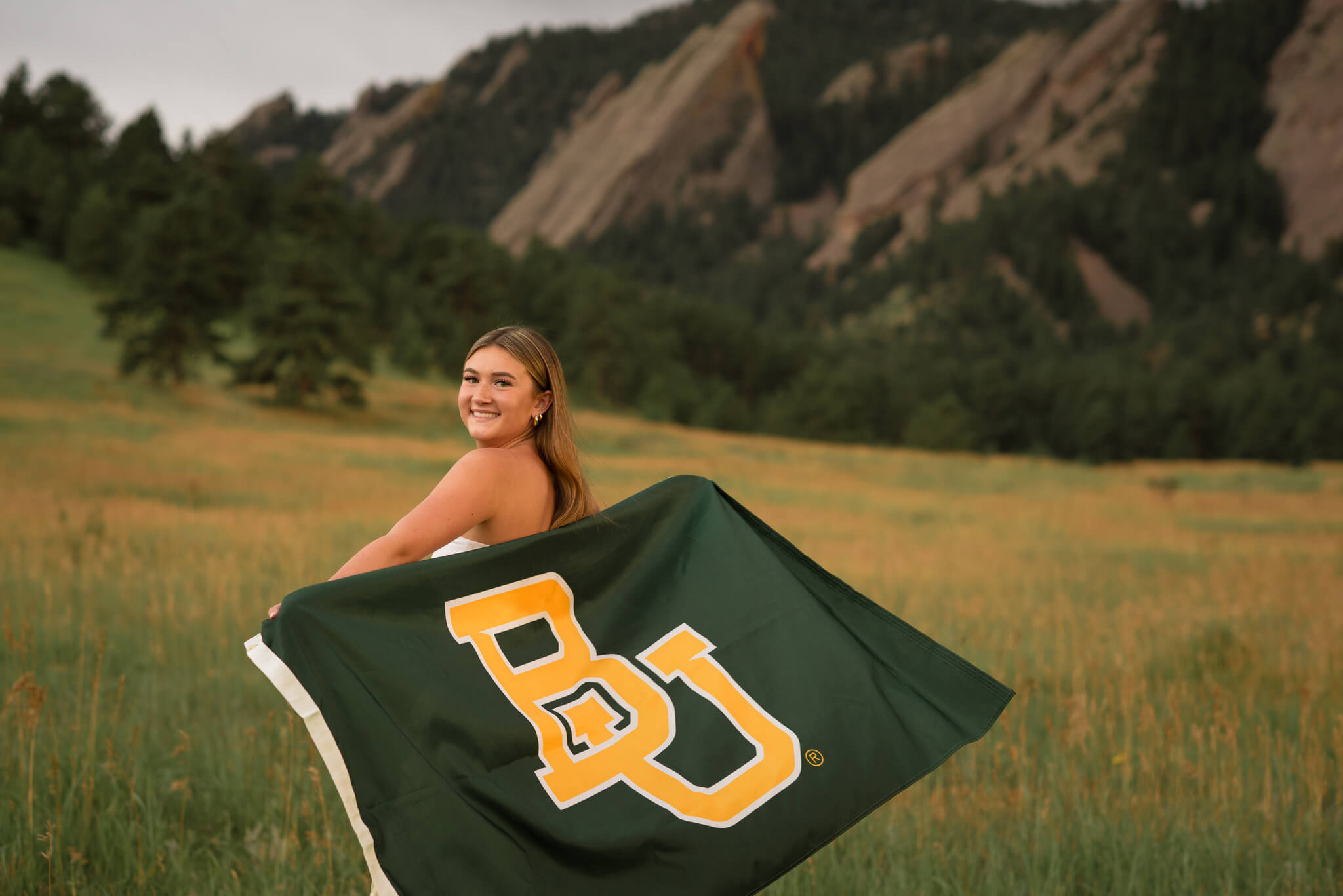 Boulder senior photo at Chautauqua Park with Flatirons mountain view and Baylor University flag at sunset