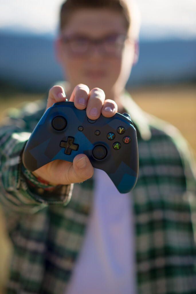 Creative Colorado senior picture highlighting a senior guy's love of gaming with his video game controller.