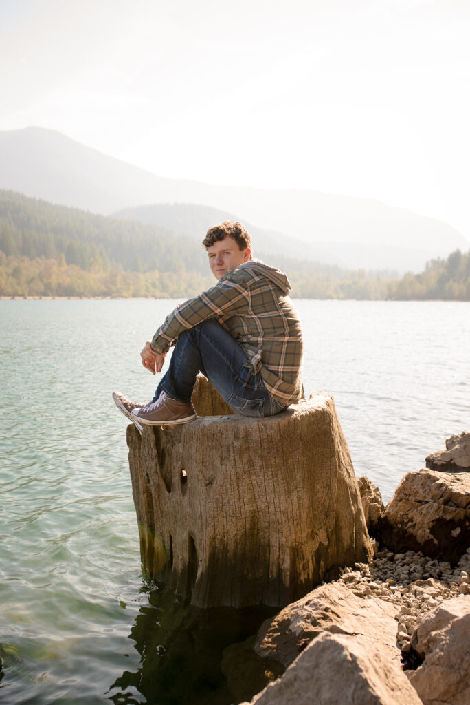 Boy sitting on tree stump in Rattlesnake Lake