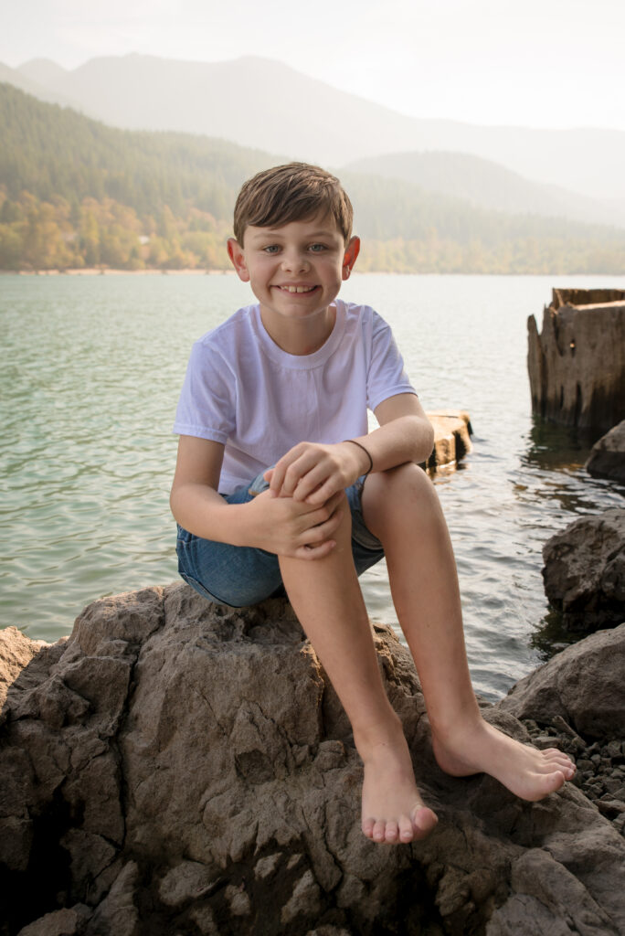 Boy Sitting on rock at edge of Rattlesnake Lake