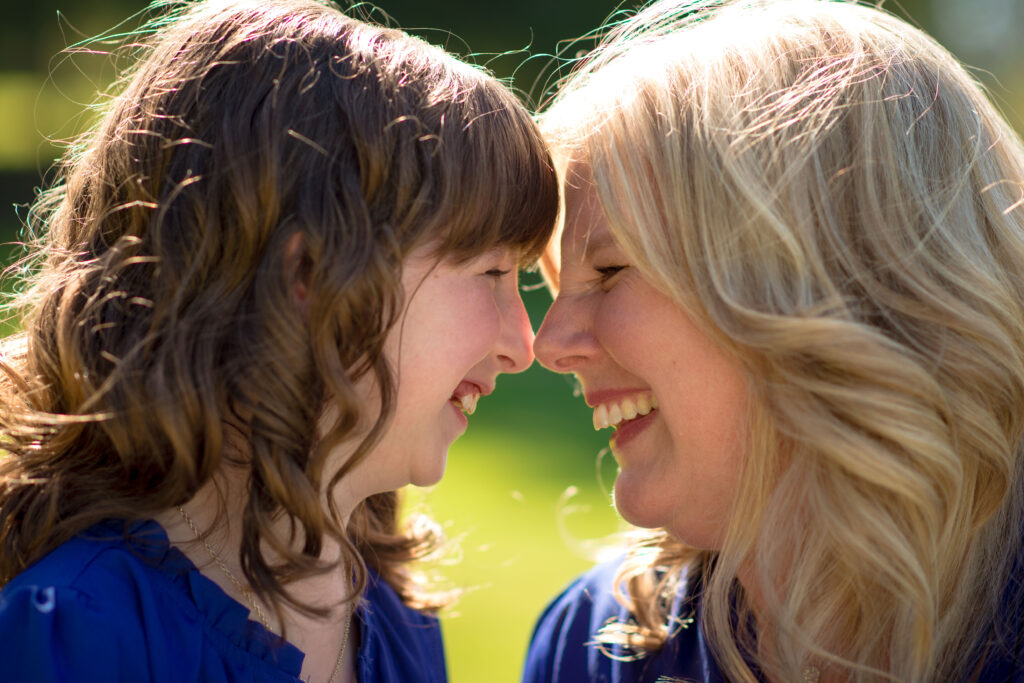 Mom and daughter are touching foreheads and laughing at each other at Big Rock Park in Sammamish, WA.